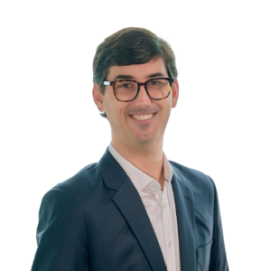 Person in a suit smiling against a white background.