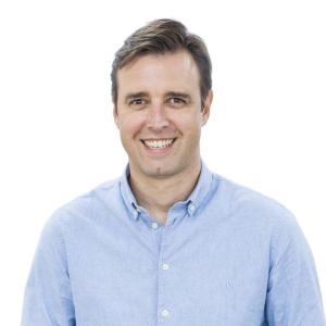 Smiling person in a light blue shirt against a white background.