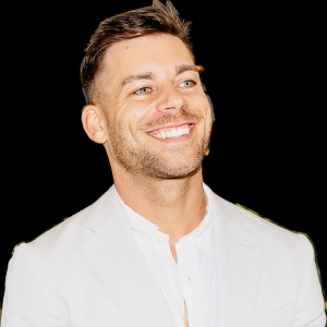 Smiling person in a white suit against a white background.