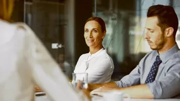 People sitting at a table in a meeting room.