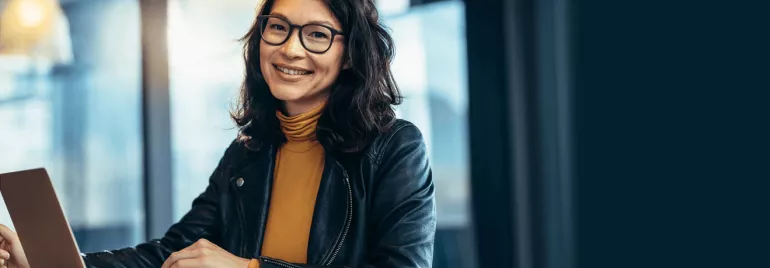 Female professional with glasses working on laptop