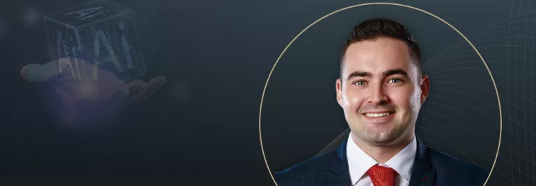 A professional portrait of a smiling man in a suit and red tie, overlaid on a dark background featuring subtle graphic lines and a futuristic hologram of "AI" in a cube held by a hand.